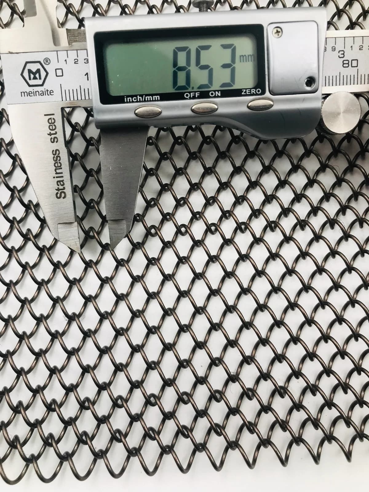 Caliper measurement shown as a sample-review process example, not a dimension for the current model