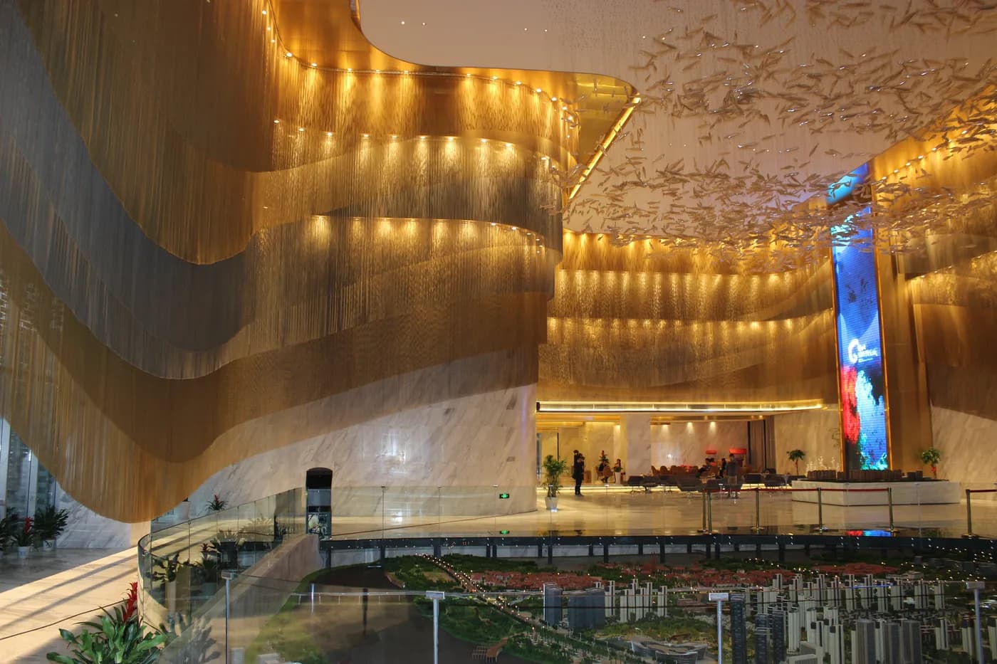 Wide view of sales center coil drapery architectural metal mesh installation