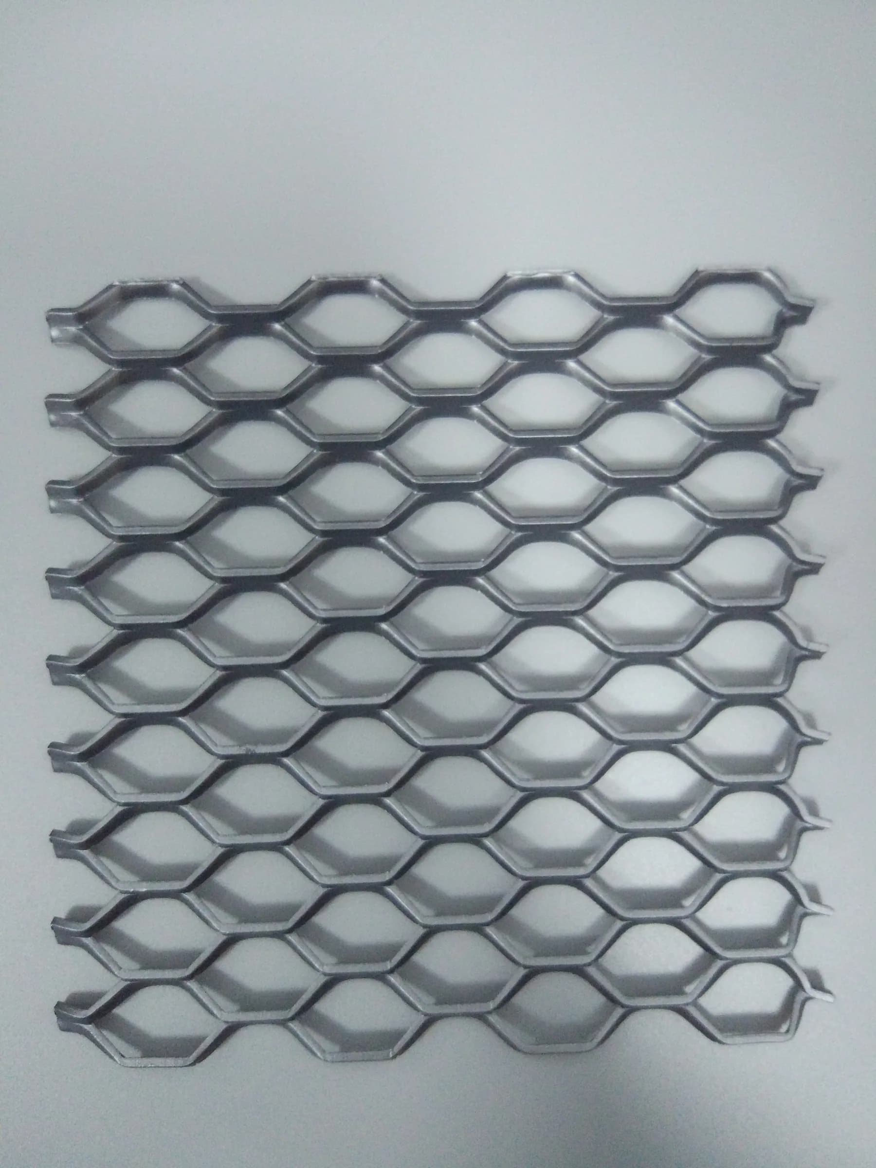 Expanded architectural metal mesh detail showing strand geometry and directional opening