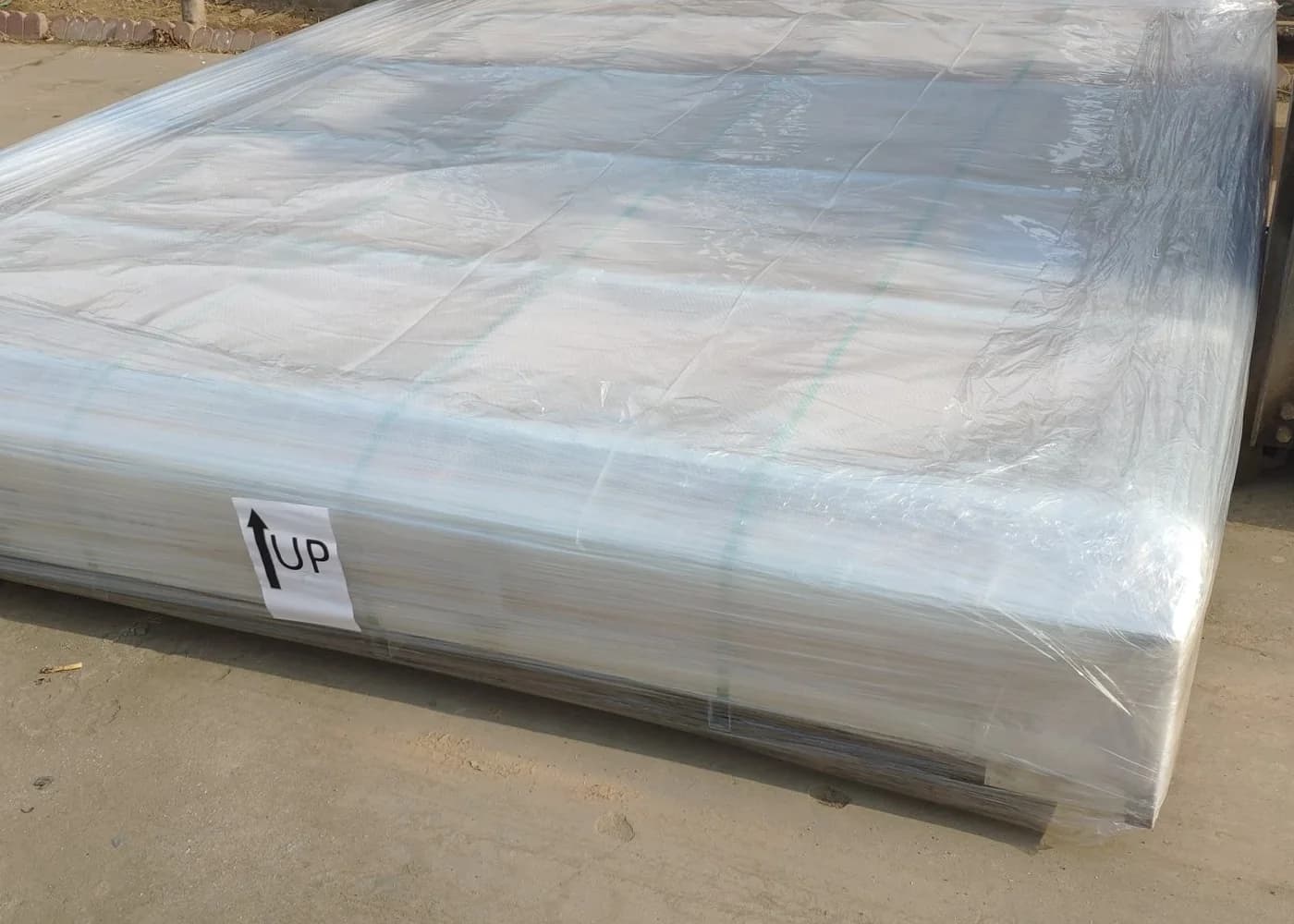 Flat order package protected with wrapping and an upright orientation label before loading