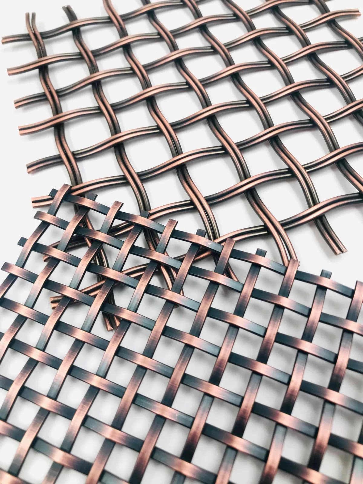 Curved and flat mesh structures with copper-coloured and dark visible surfaces