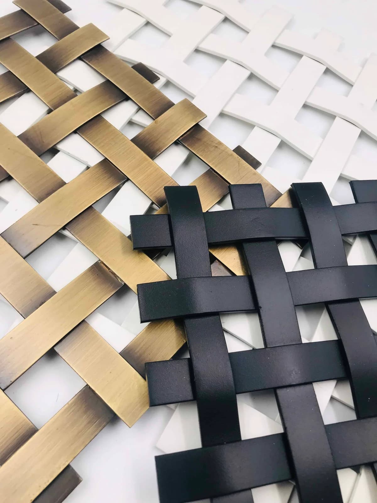 Flat-strip mesh samples with light, dark and brass-coloured visible finishes